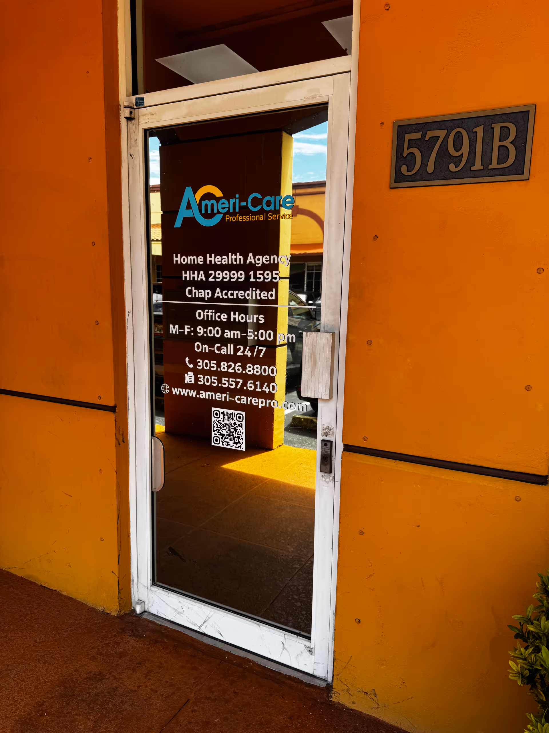 Glass entry door with Ameri-Care signage on an orange building exterior.