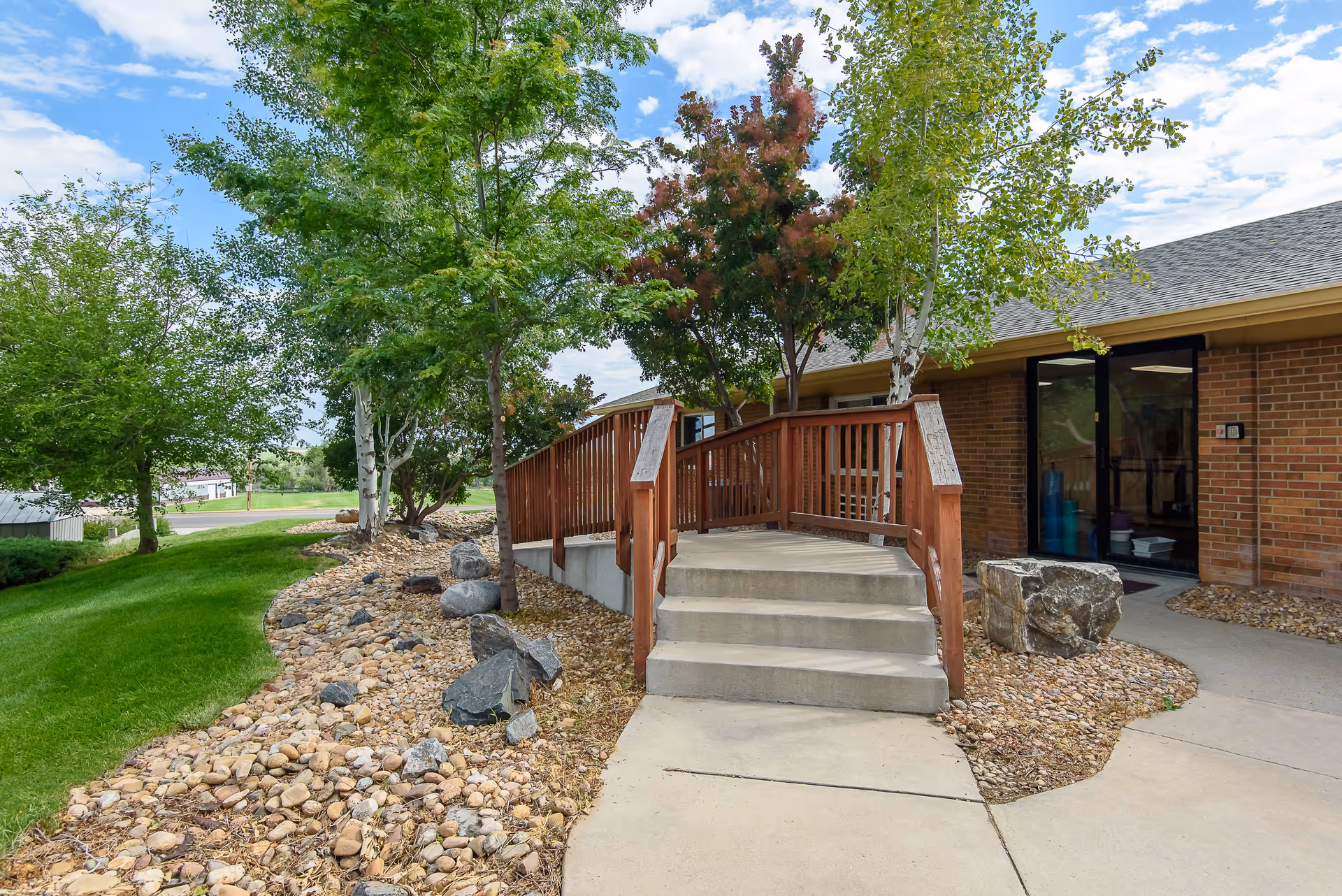 Valley View Villa entrance with a wooden ramp, brick exterior, and rocks.