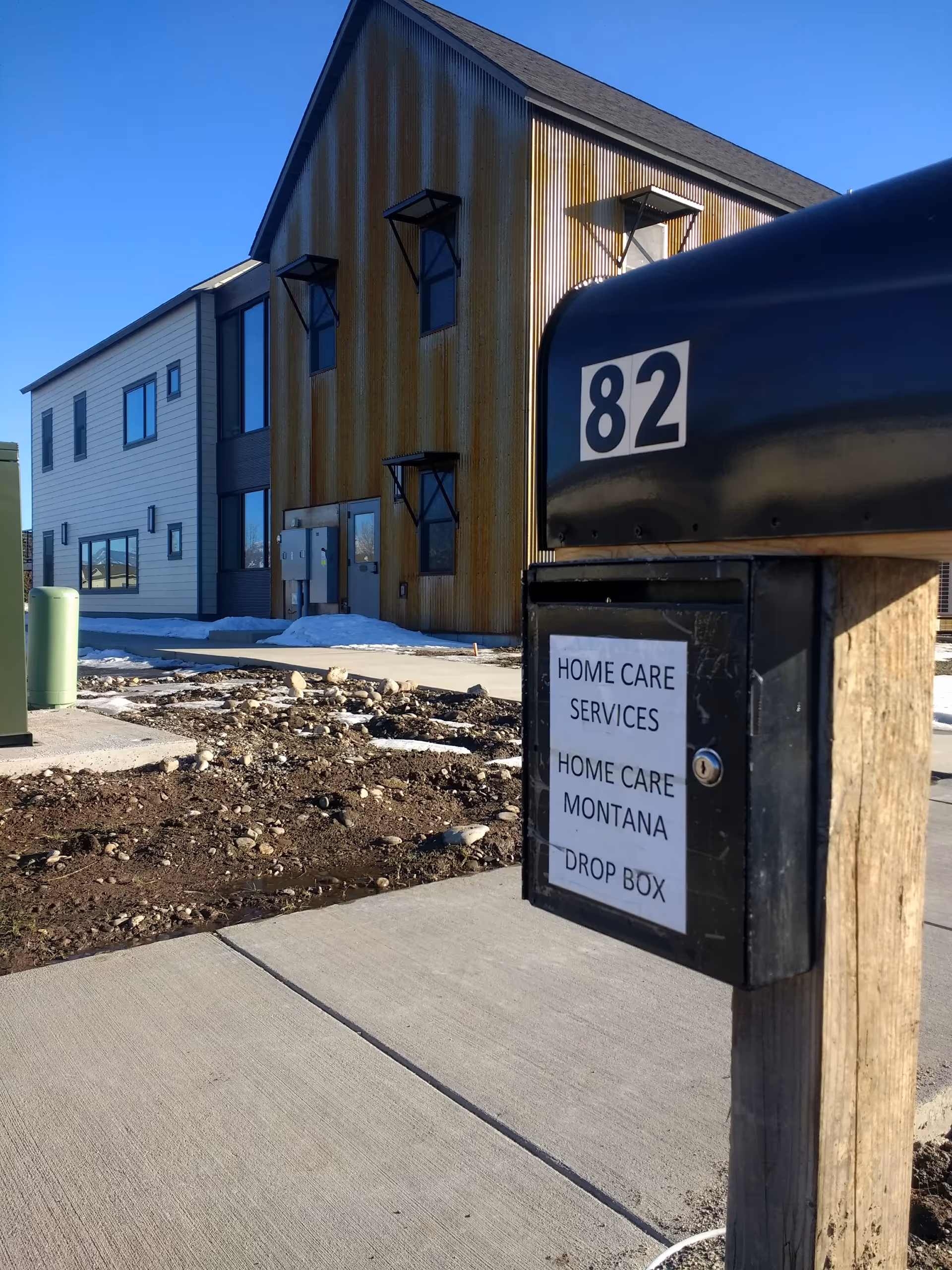 Exterior view of a modern senior care facility with a drop box in the foreground