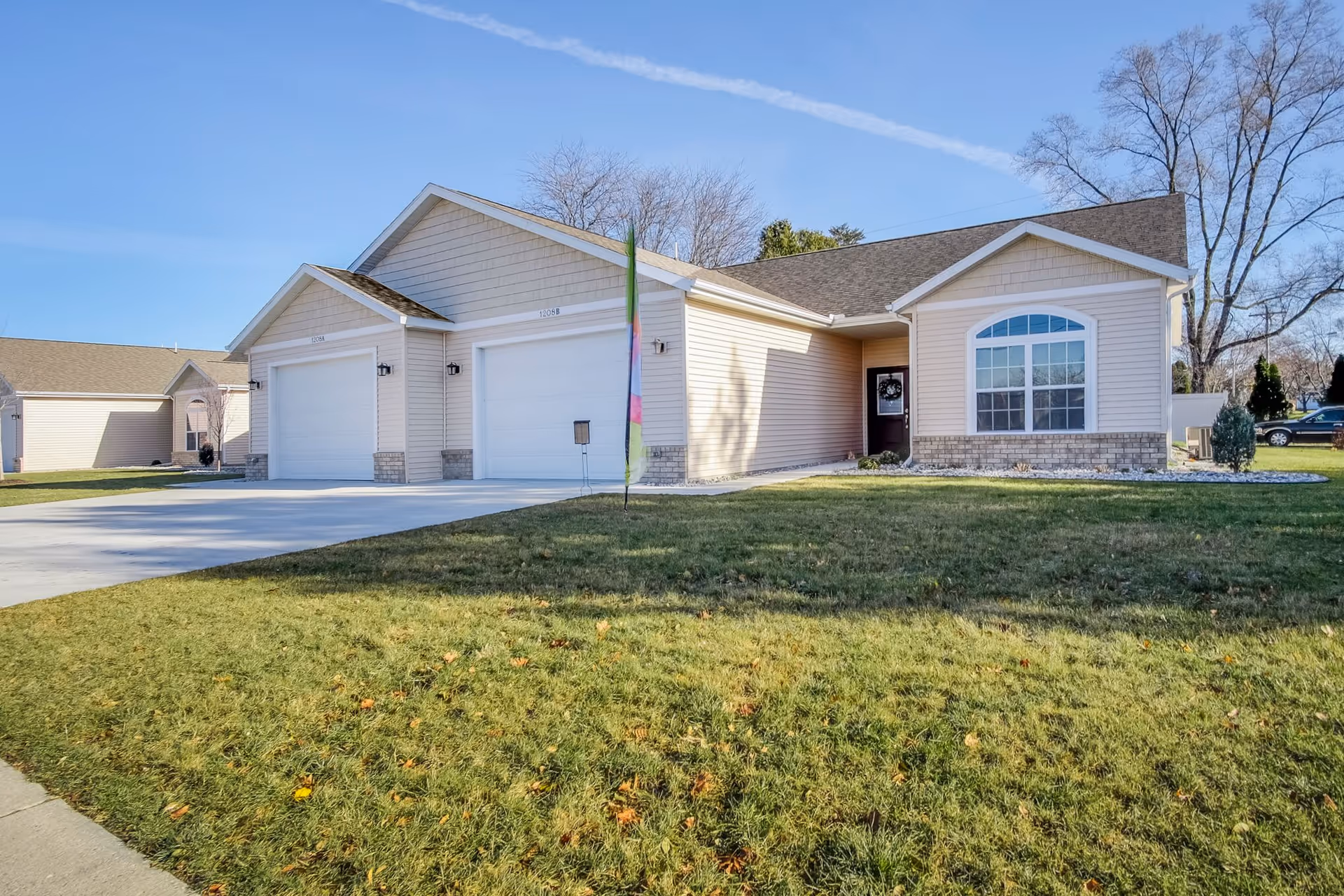 Single-story senior living facility with three garage bays and a well-kept lawn.
