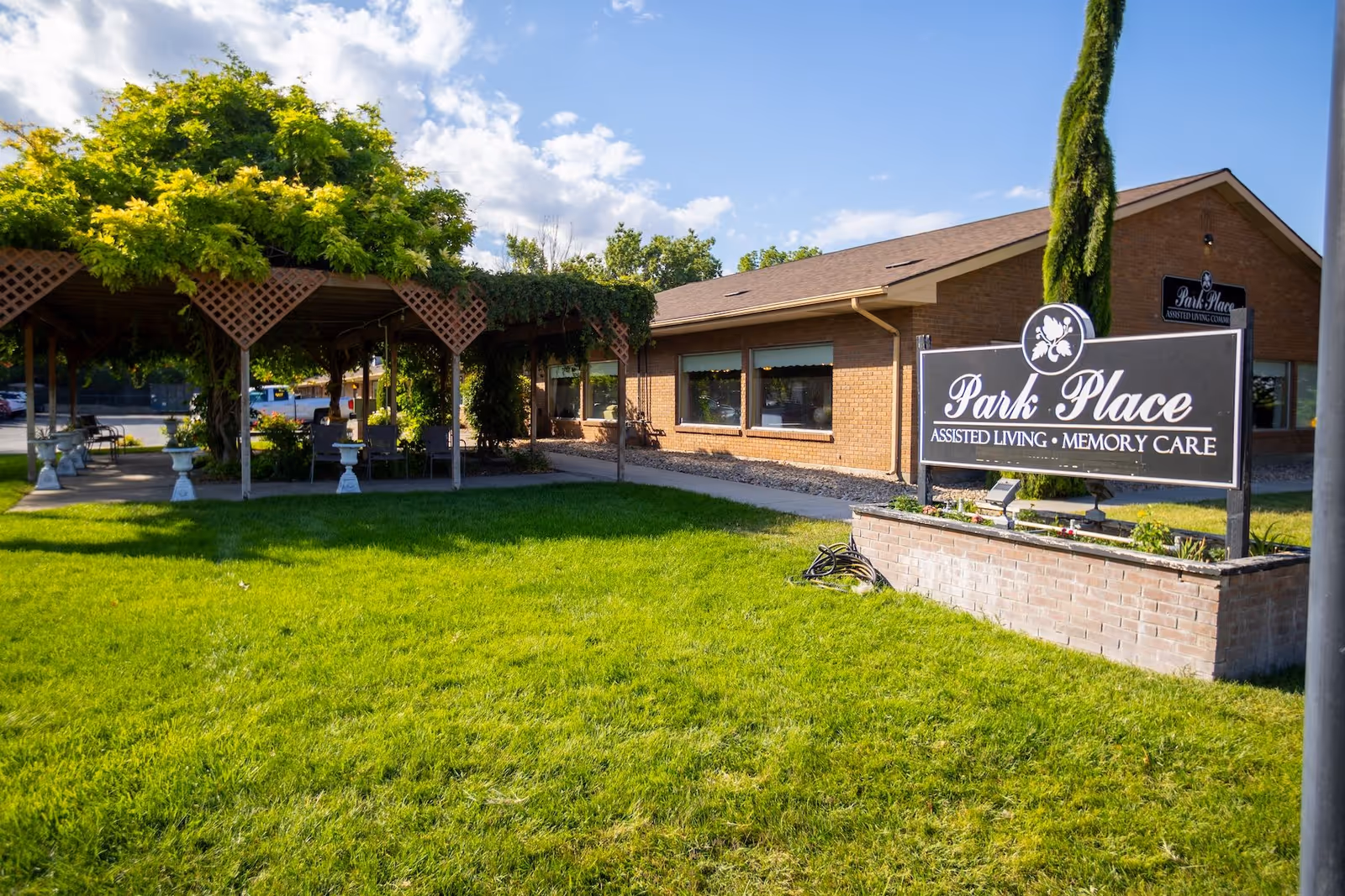 Brick senior living facility exterior with Park Place sign and manicured lawn.