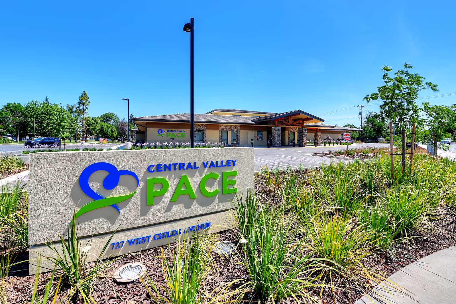 Exterior view of Central Valley PACE facility with entrance and landscaped sign in foreground.