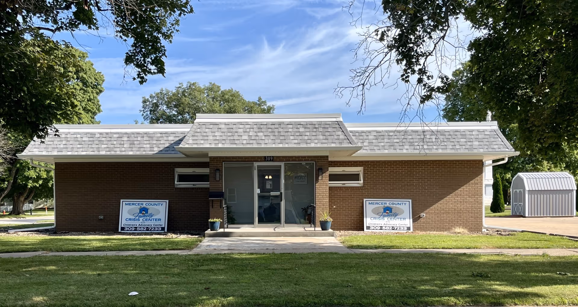 Brick single-story building with front entrance and two signs reading Mercer County Crisis Center