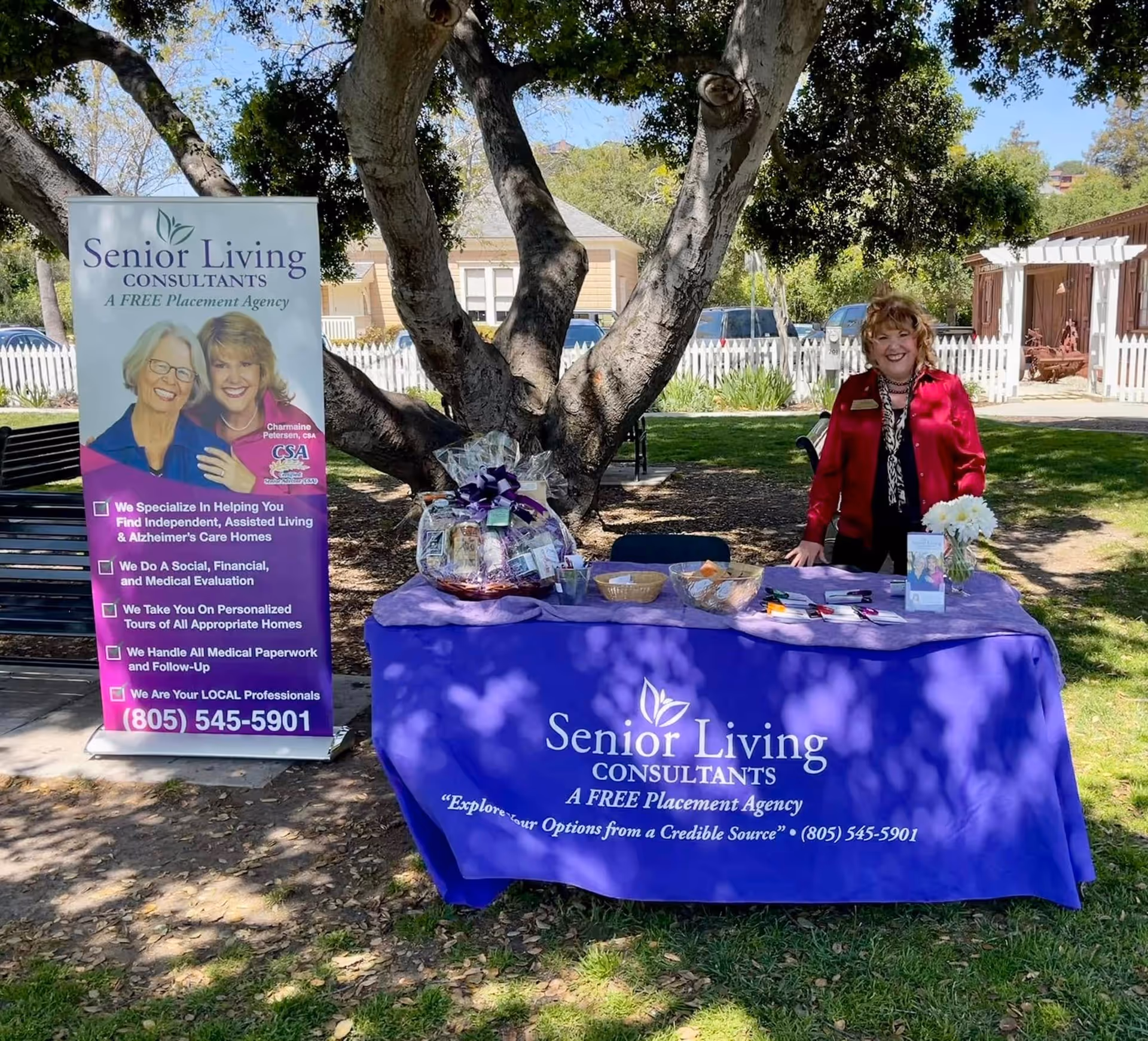 Outdoor table display for Senior Living Consultants with purple tablecloth and banner