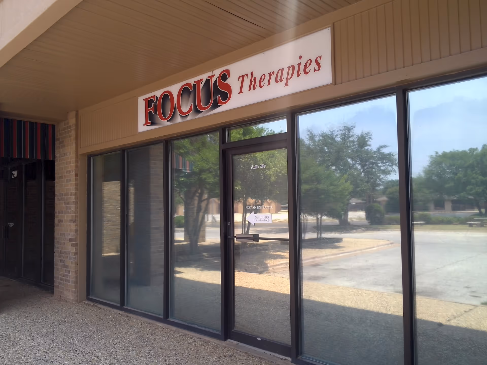 Front of a building with a large FOCUS Therapies sign above glass doors.