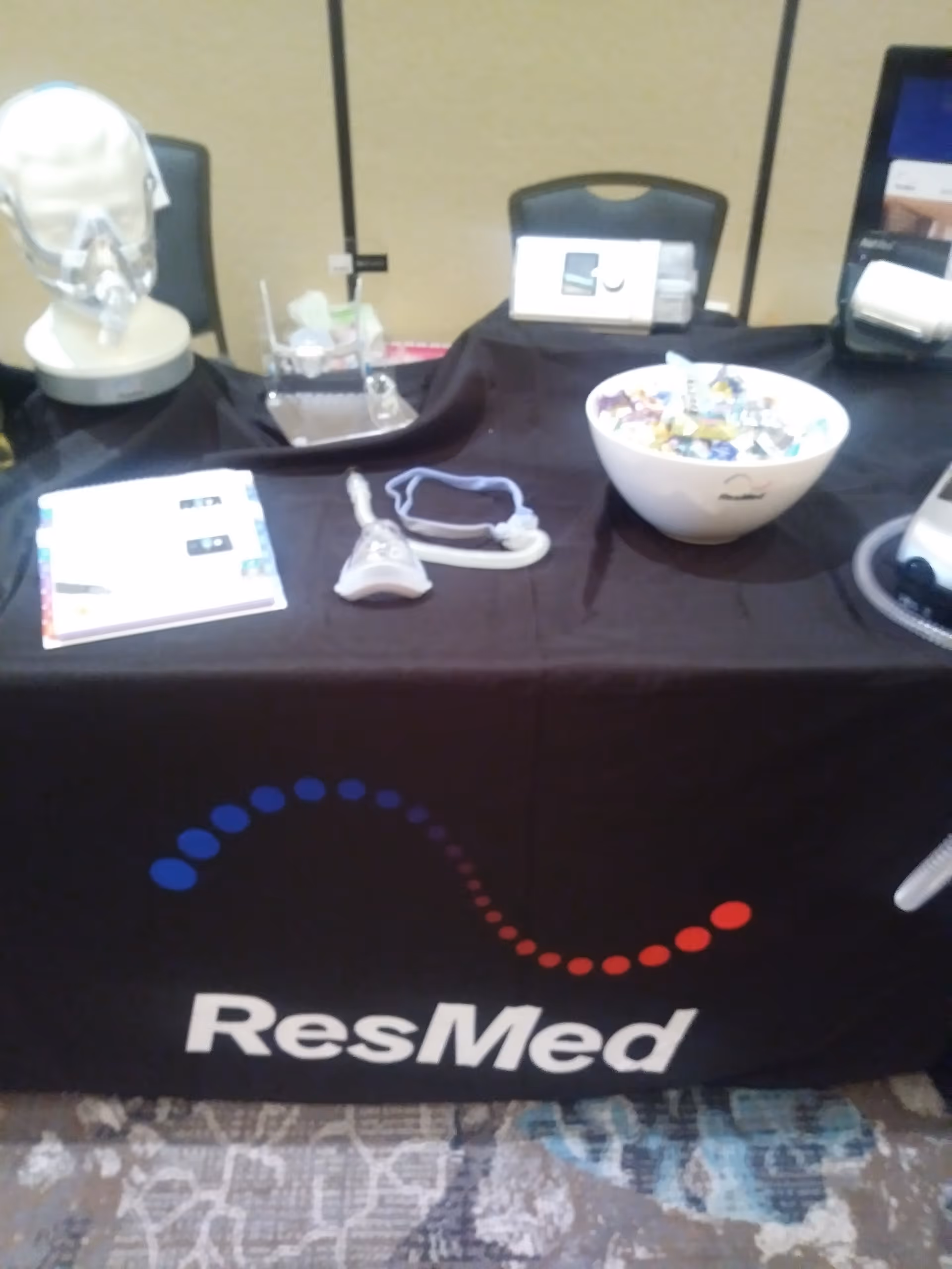Medical equipment display on a table covered with a ResMed cloth at an indoor booth.