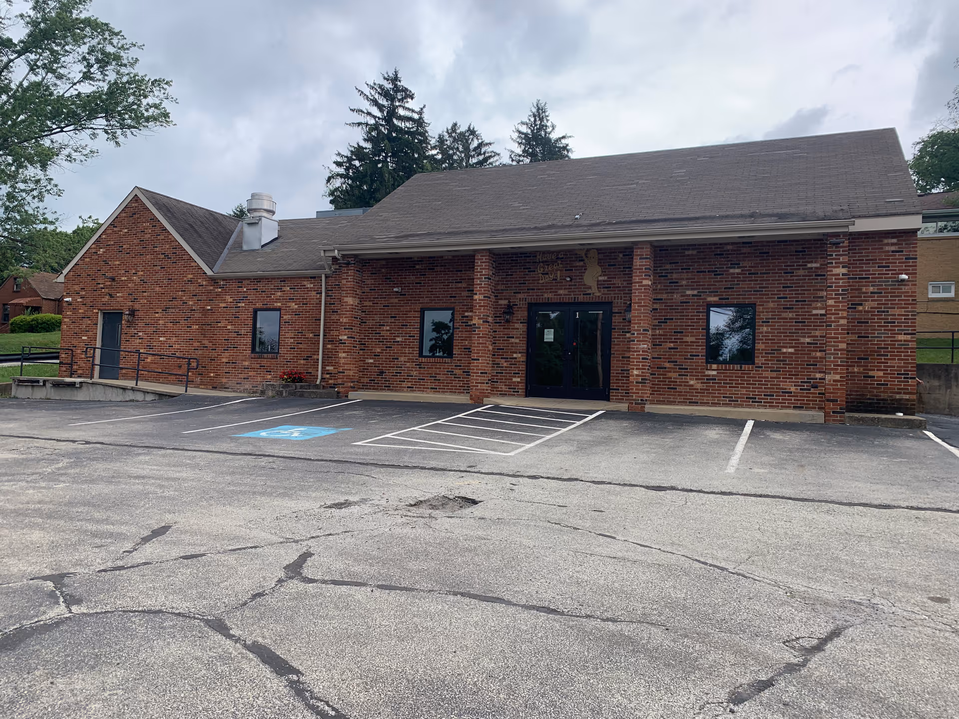 Brick, single-story Caring Mission Home Care building with a sloped roof and accessible front parking.