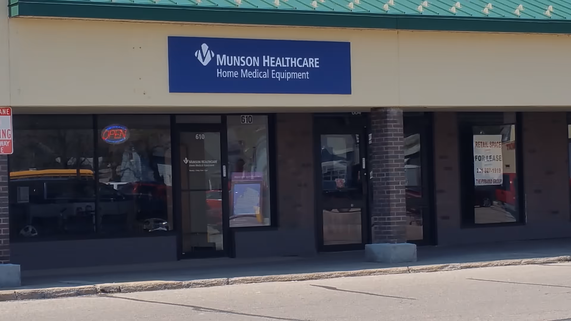 Front of a Munson Healthcare storefront with glass doors and a blue sign.