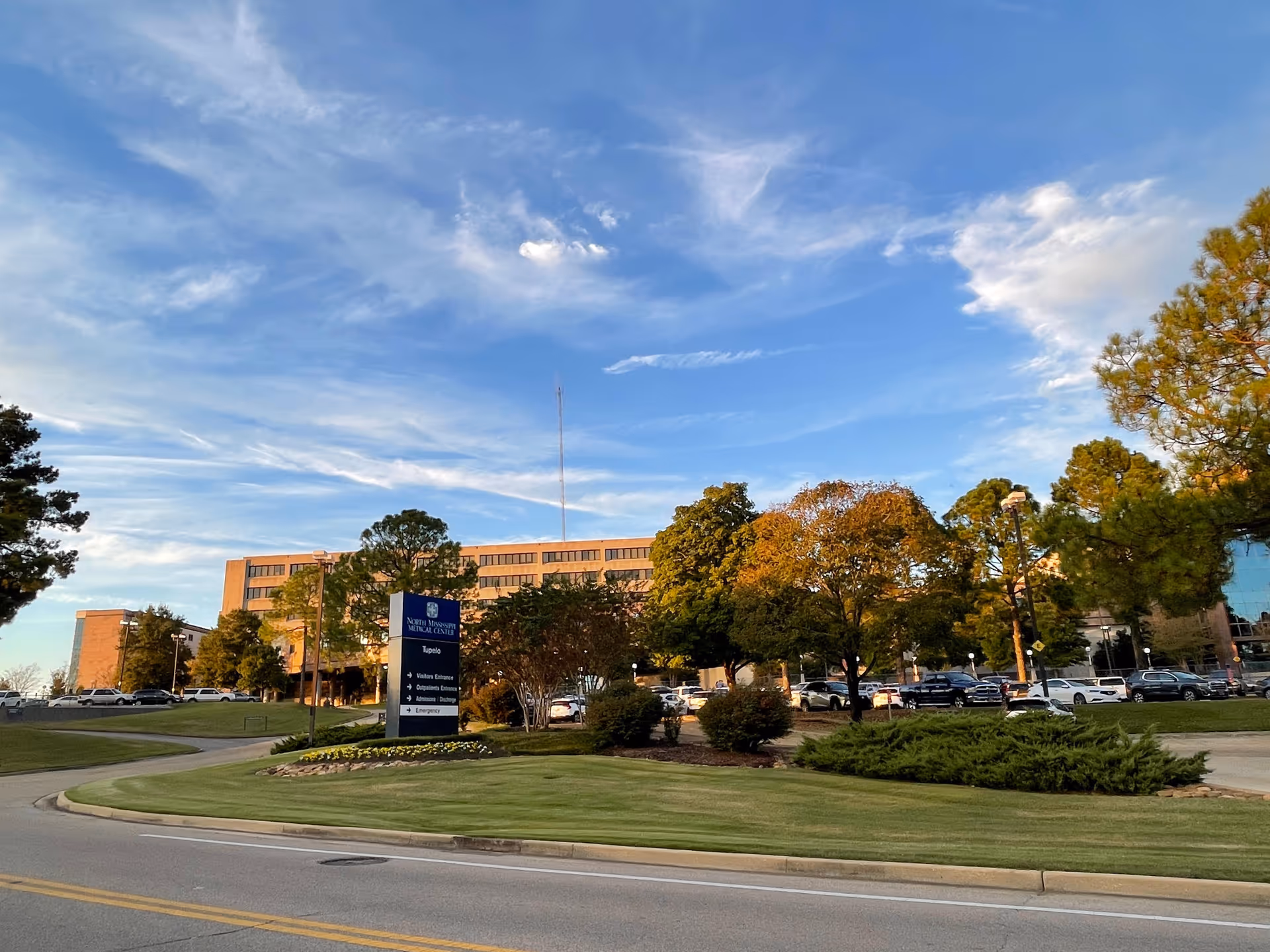 Front view of North Mississippi Medical Center Tupelo with parking and trees.