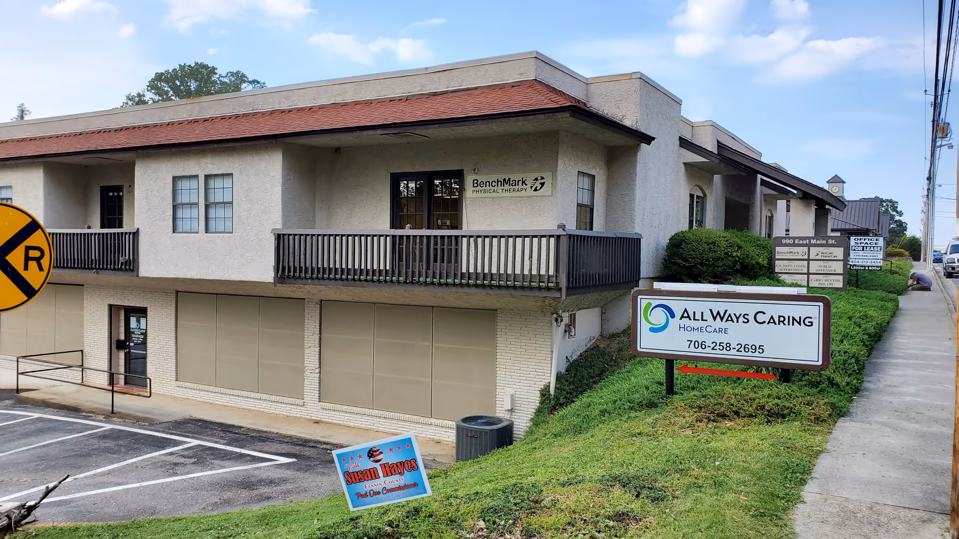 Two-story building facade with All Ways Caring HomeCare sign and adjacent parking area.