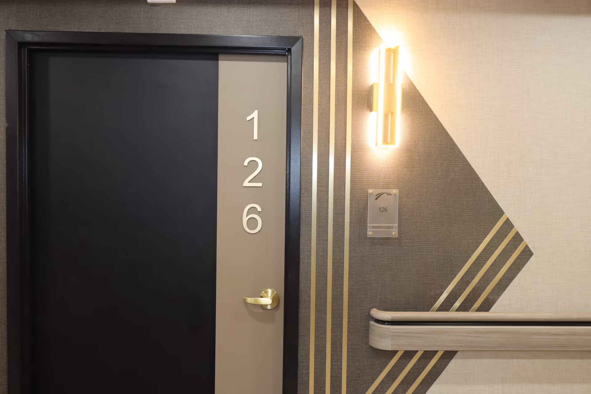 Interior hallway with a dark door labeled 126 and geometric wall design.