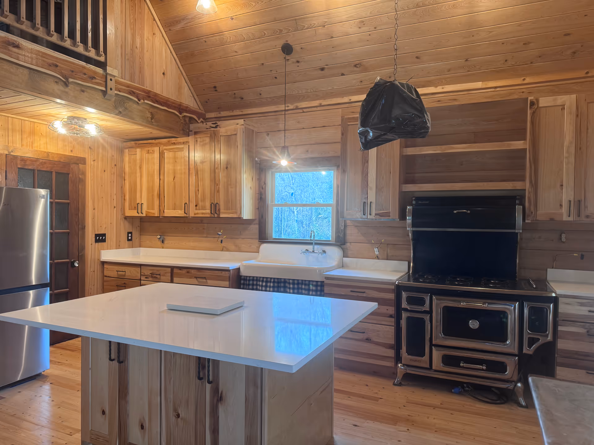 Rustic wooden kitchen with island, sink, stove, and ample cabinets.
