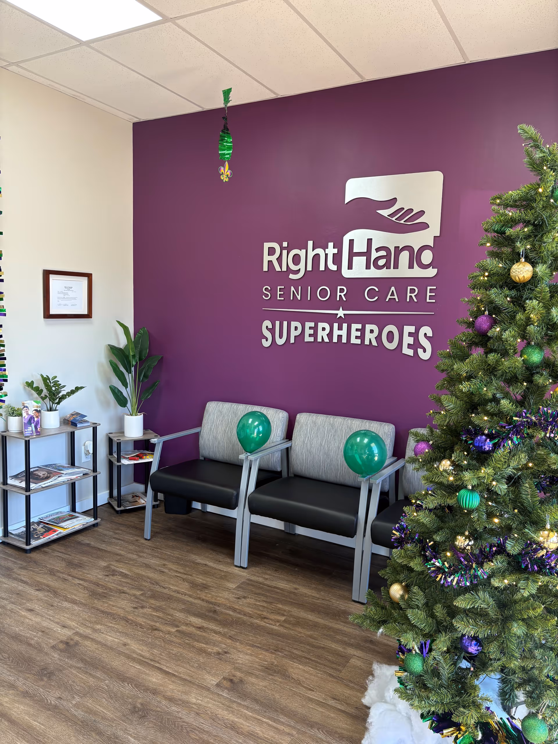 Interior lobby with a purple wall, Right Hand Senior Care sign, chairs, and a Christmas tree.