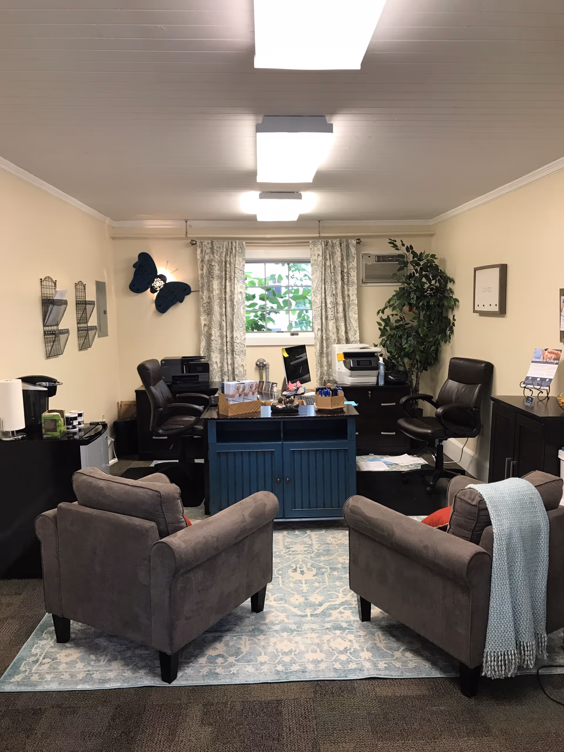 Reception area with desks, chairs, and office equipment in a Timberland Home Care facility.