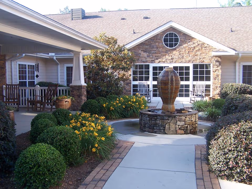 Exterior courtyard of Hospice of Randolph with fountain, stone walkway, and seating area.