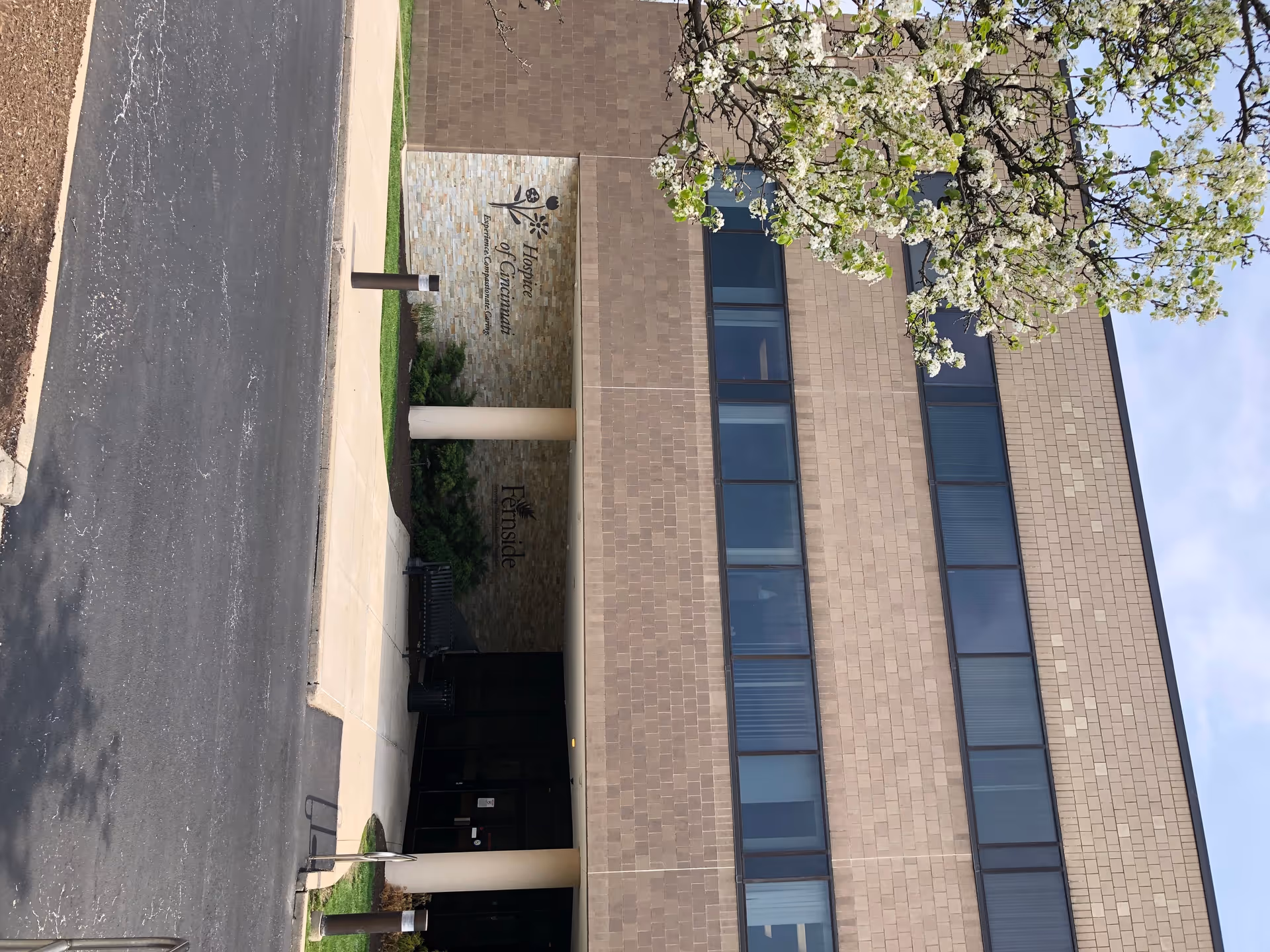 Exterior view of Hospice of Cincinnati administrative office building with a blossoming tree.