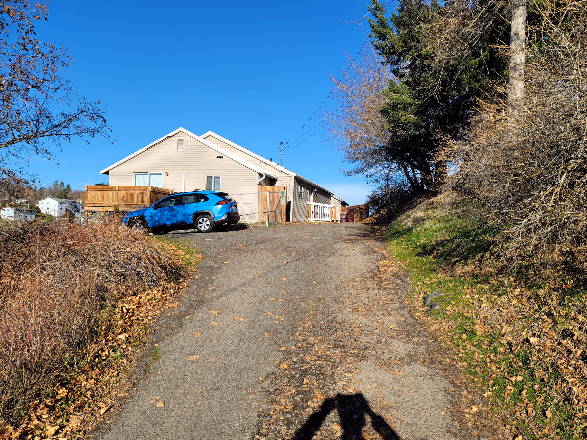 Residential building at Whitman Street Adult Family Home with a blue car on a driveway.