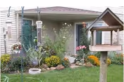 Front exterior of Willows facility with a landscaped garden and birdhouse.