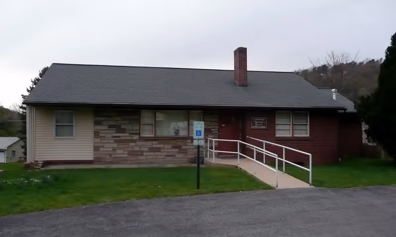 Exterior of a single-story facility with a ramp entrance and handicap sign.