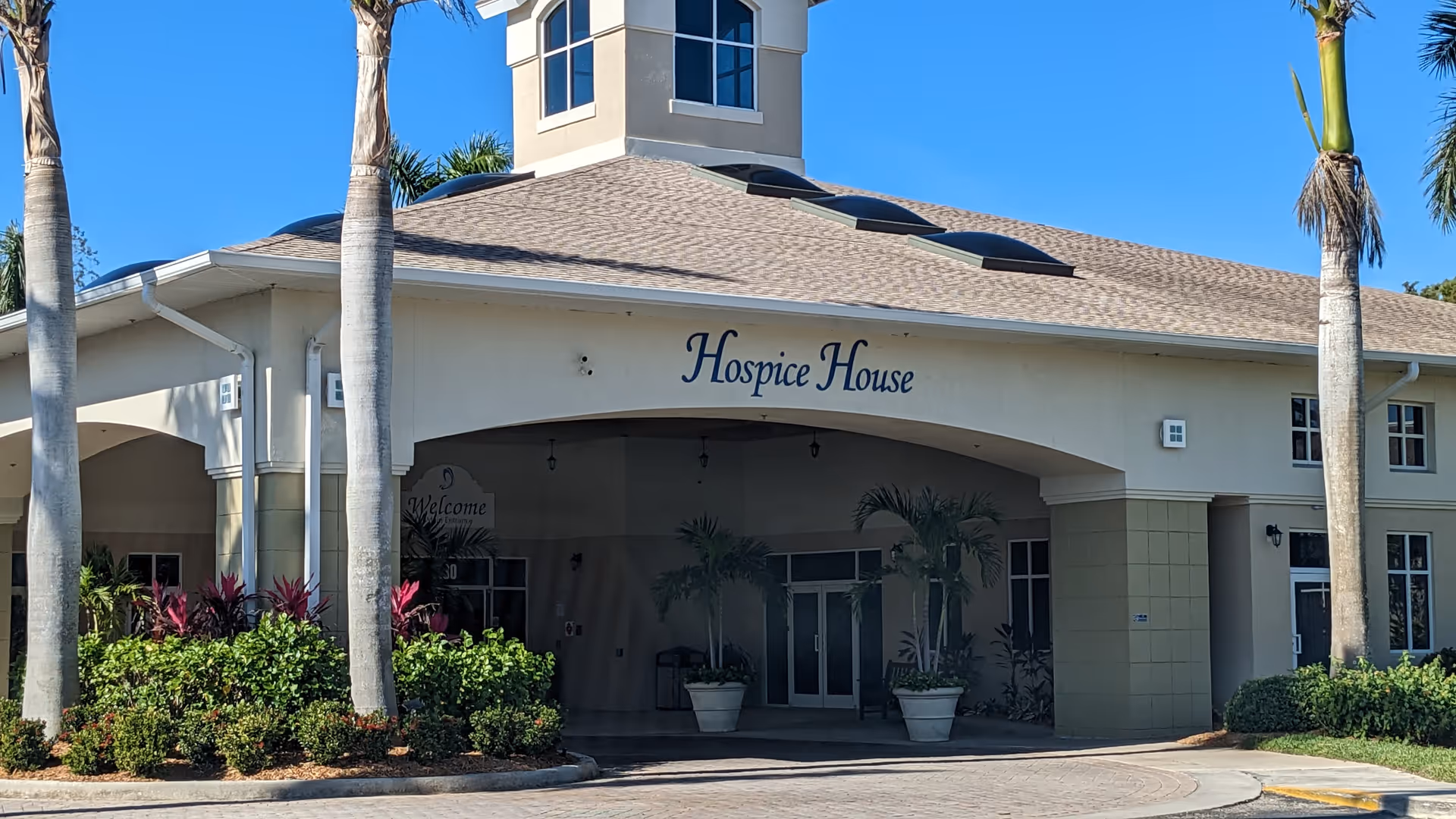 Exterior view of Hope Hospice building with palm trees and a covered entrance.