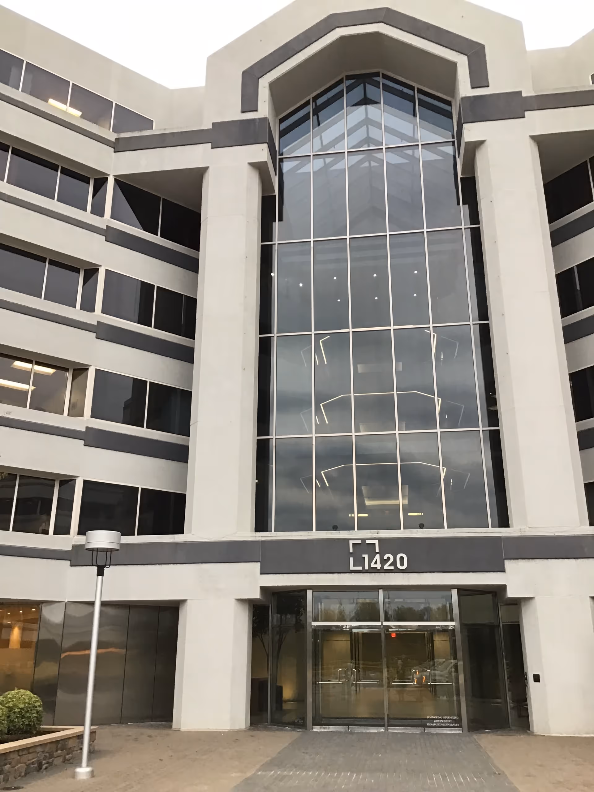 Modern senior living facility exterior with large glass facade and main entrance.