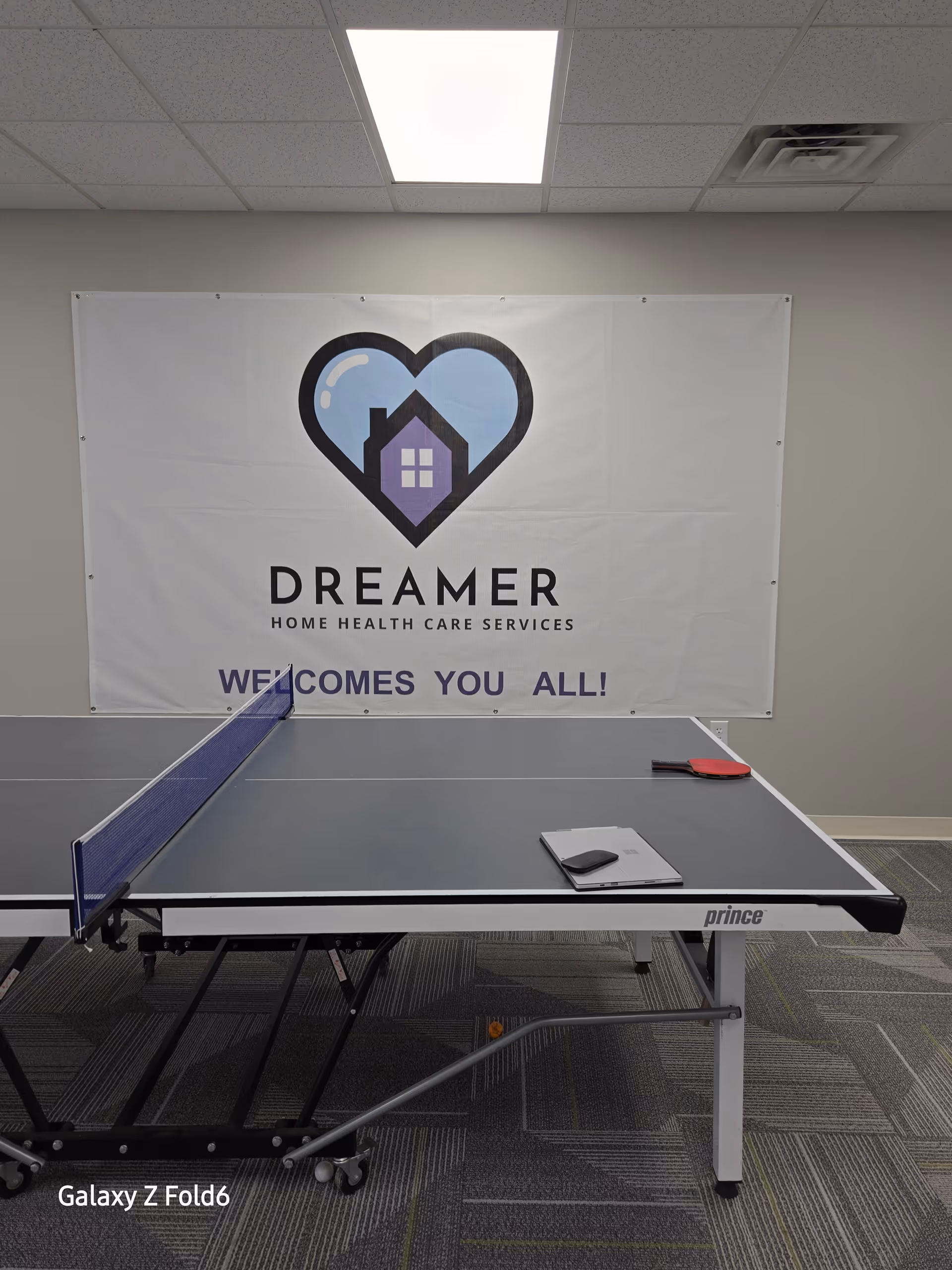 Interior room with a ping pong table and a DREAMER banner on the wall.