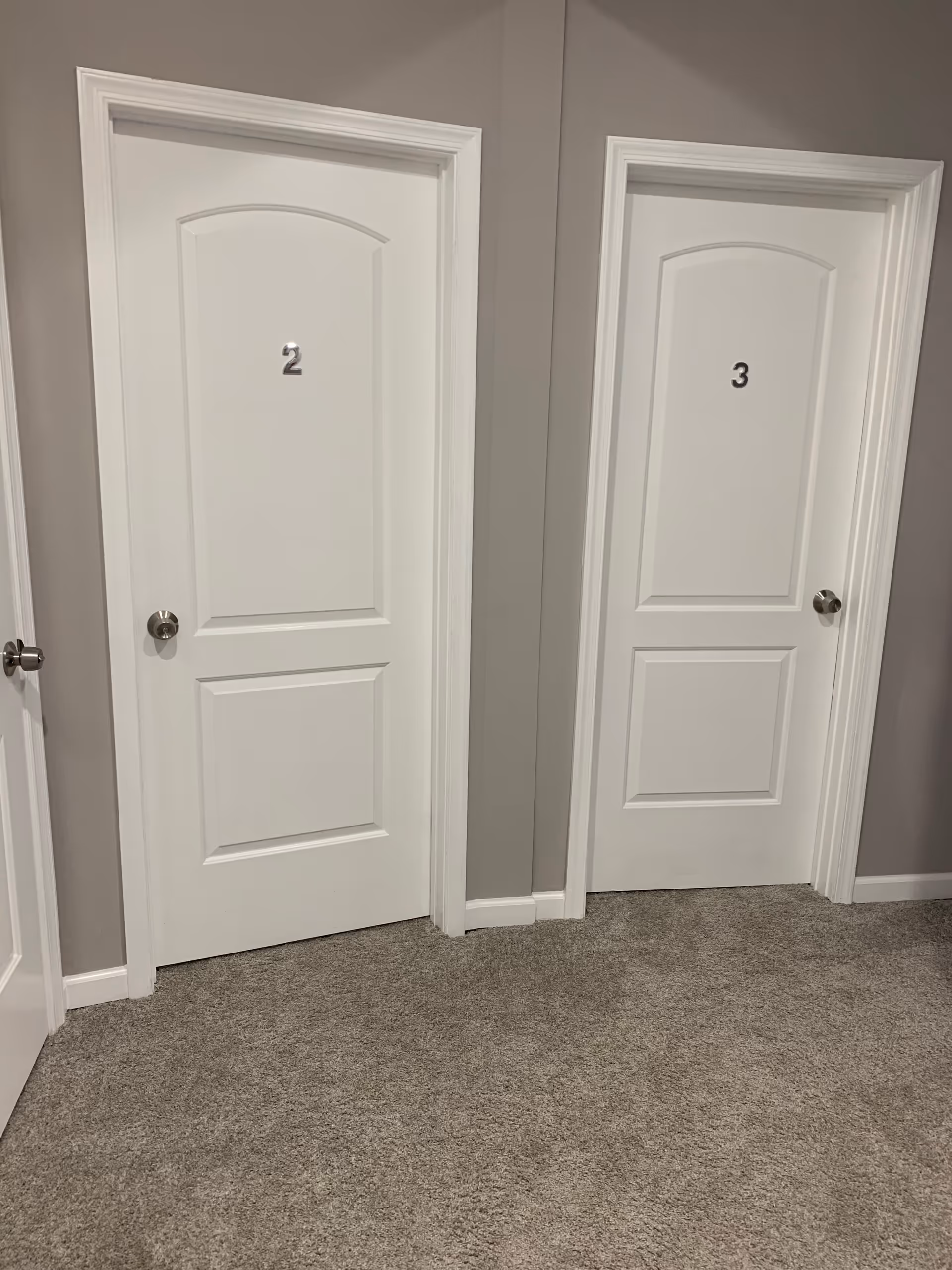 Hallway with two white doors labeled 2 and 3 in a neutral corridor.