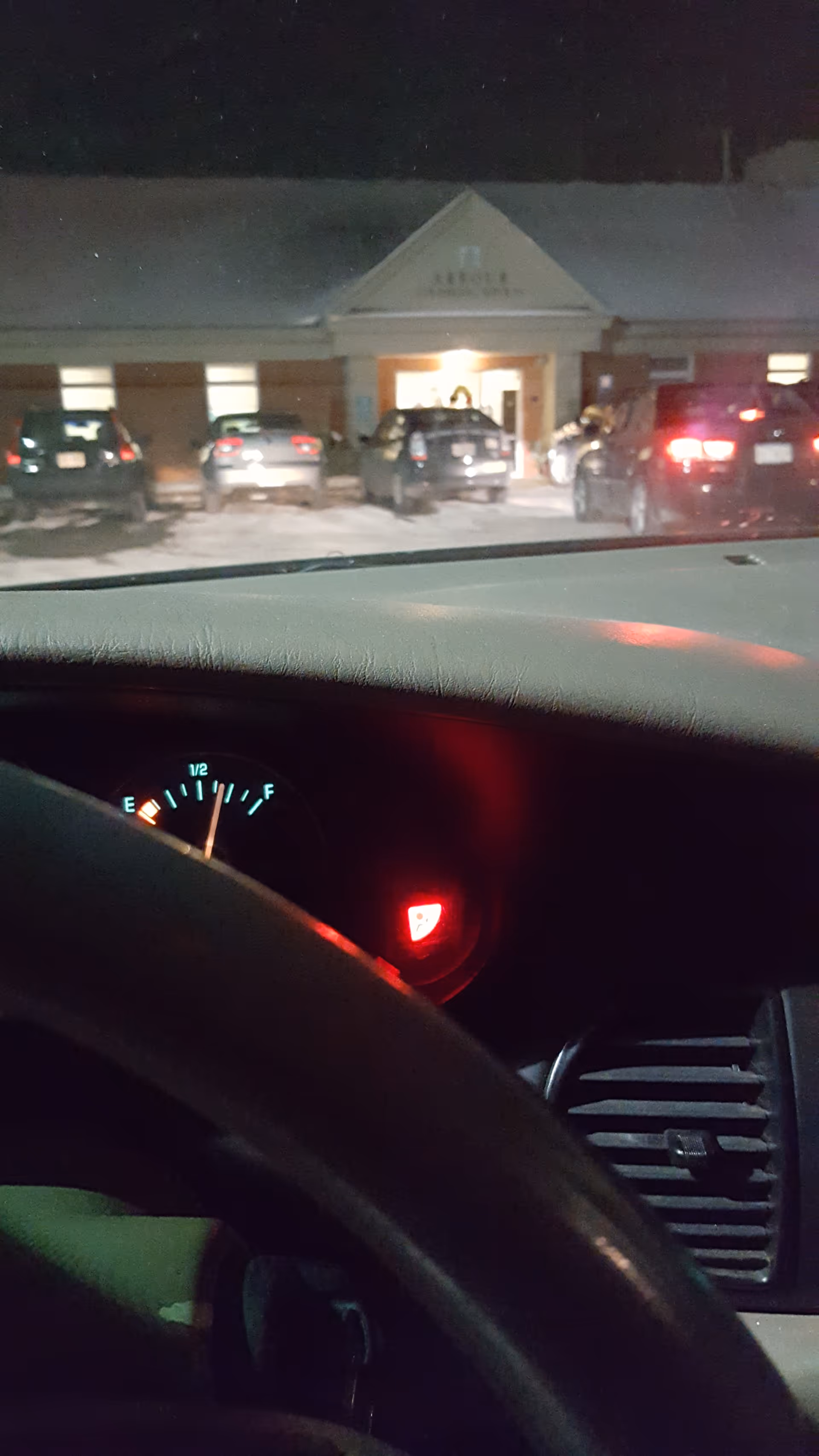 Night exterior view of Arbour Counseling Services Norwell with cars in a snowy parking lot.