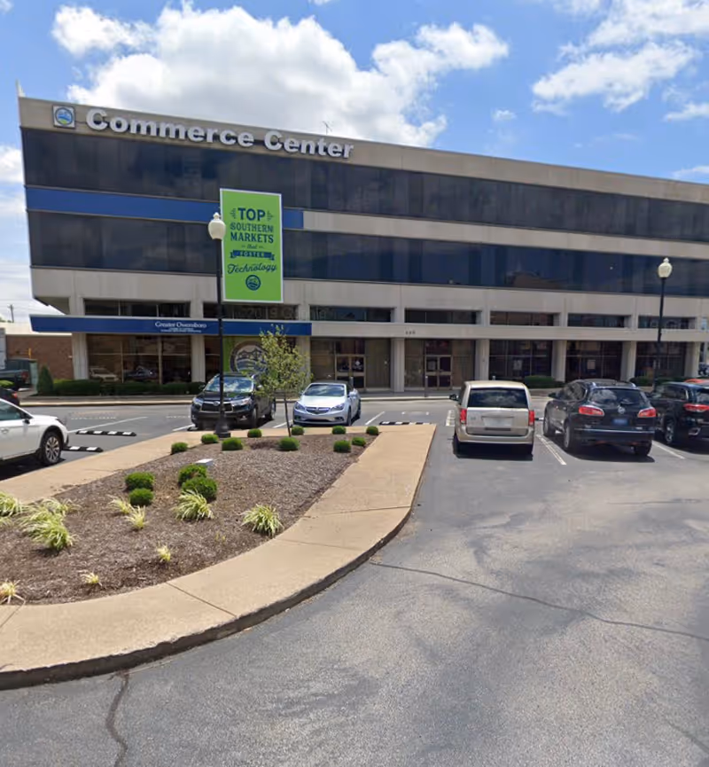 Exterior view of a Commerce Center building with a parking lot and landscaped median.