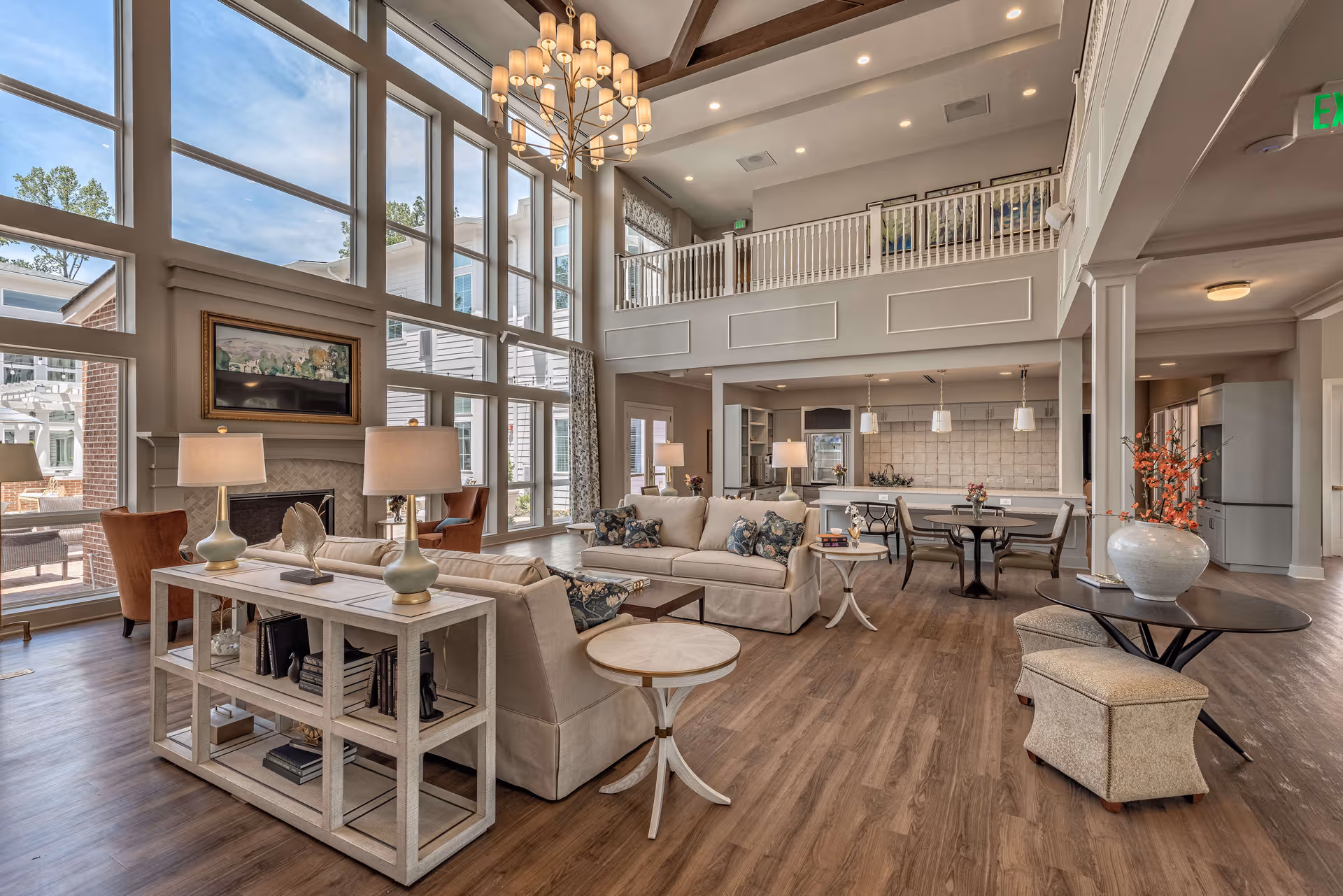 Spacious senior living lobby with large windows, comfortable seating, and an open kitchen area.