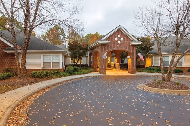 Exterior view of Brookdale Winston-Salem entrance with brick arch and curved driveway.