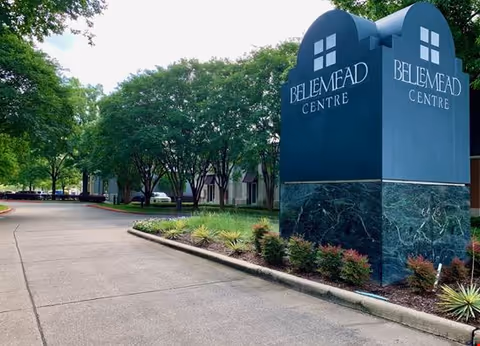 Bellemead Centre sign along a curved driveway with trees and shrubs.