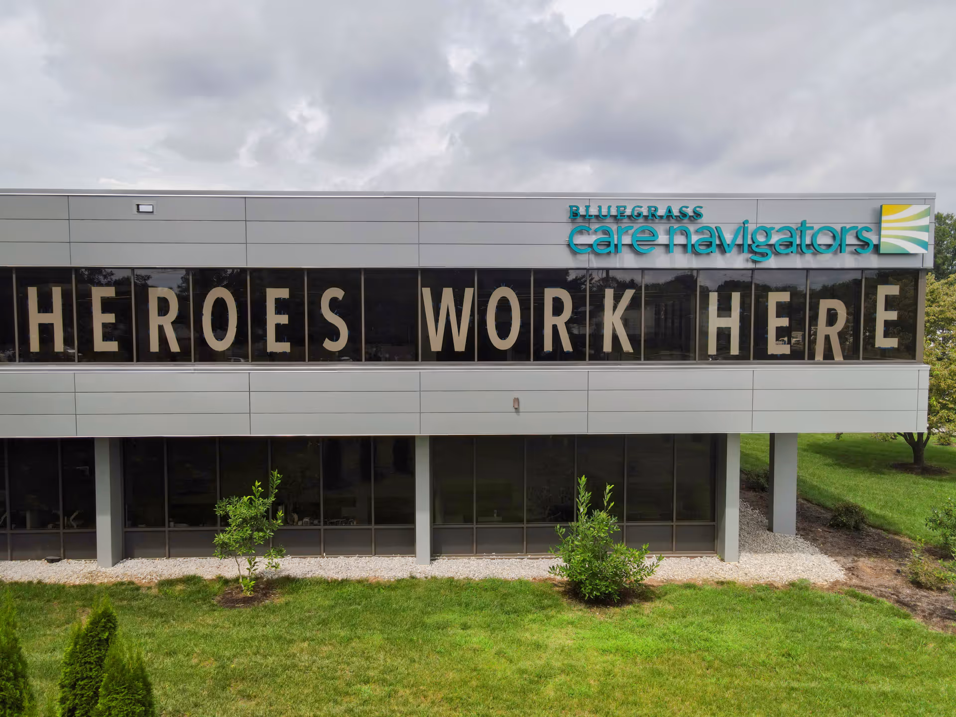 Exterior view of Bluegrass Care Navigators building with a large Heroes Work Here display.