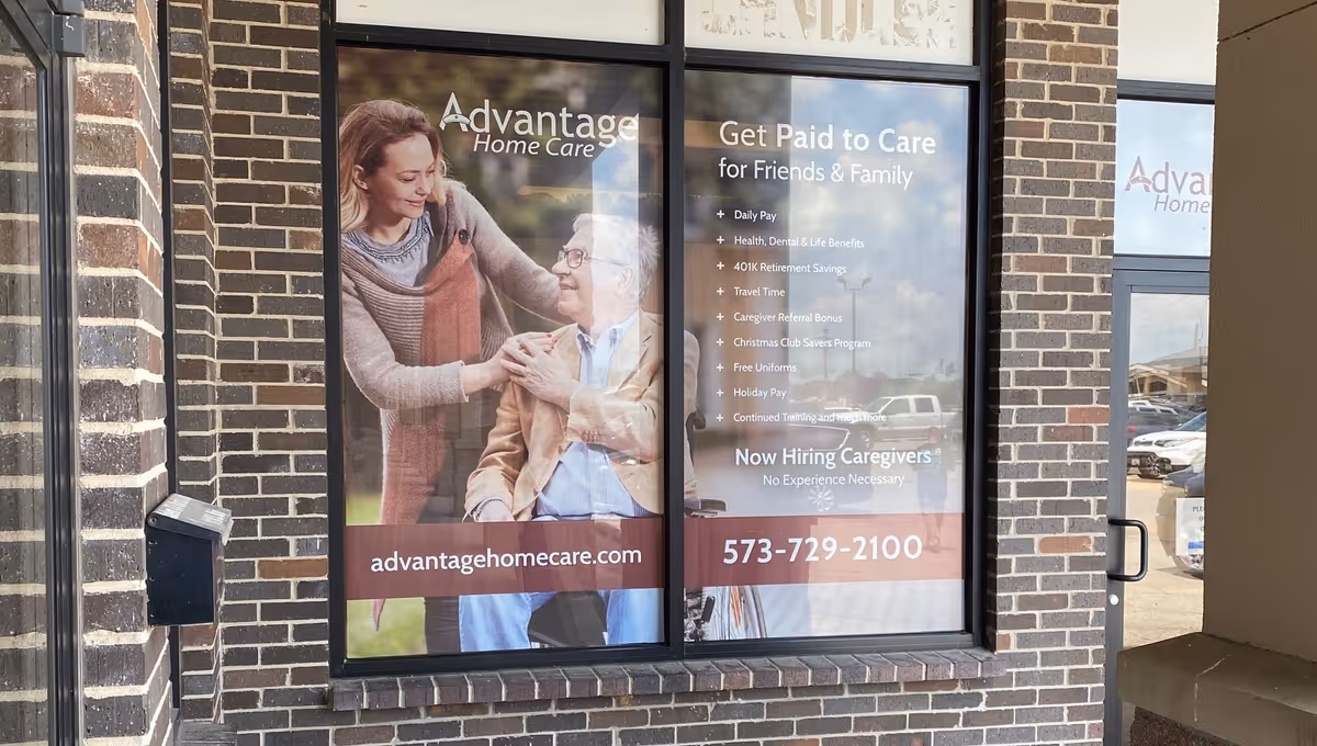 Exterior view of Advantage Home Care storefront with large posters in windows.