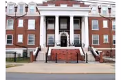 Facade of Ivy Hall Nursing Home: brick building with white columns and stairs.