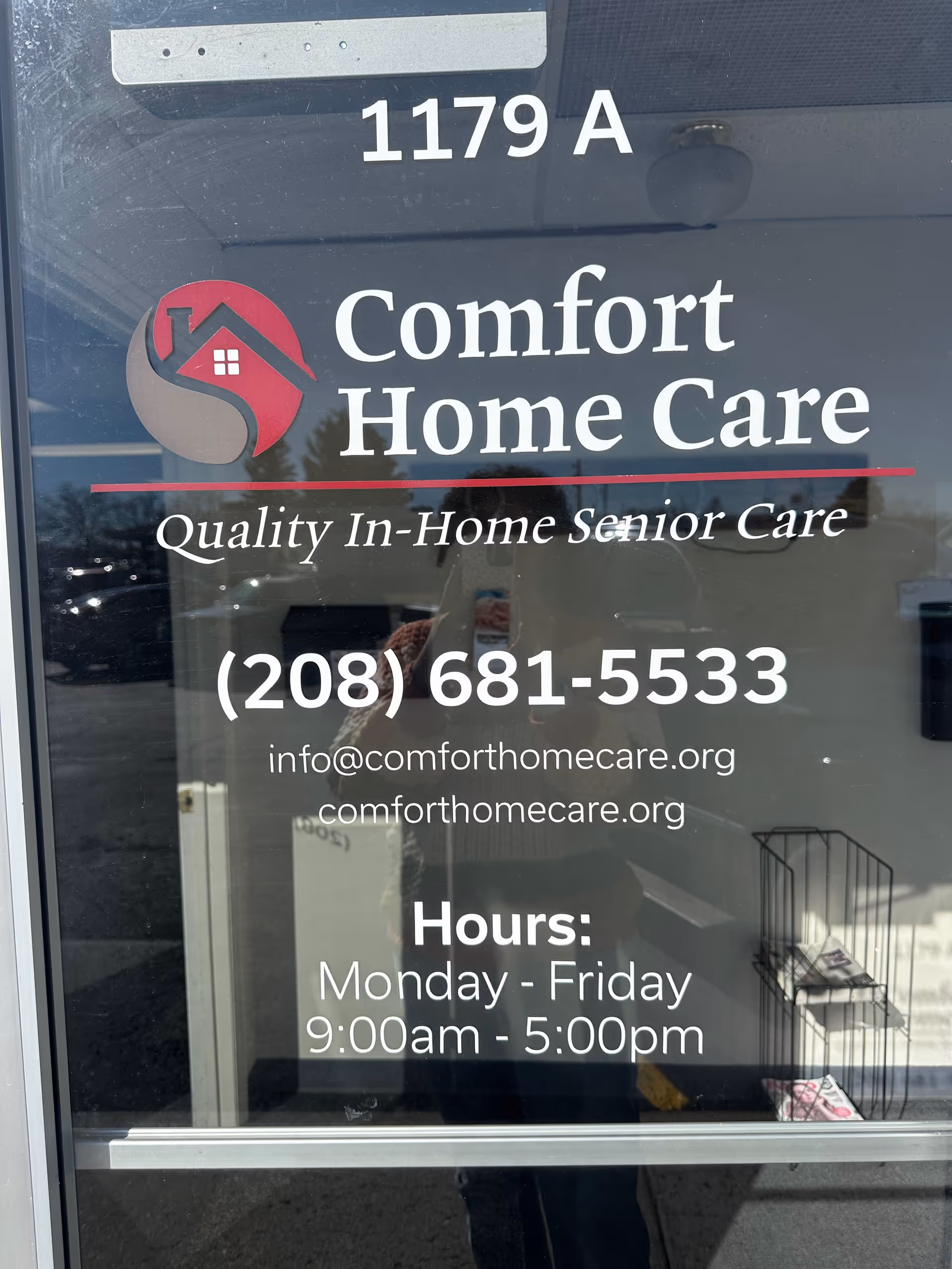 Glass storefront door with Comfort Home Care logo and hours