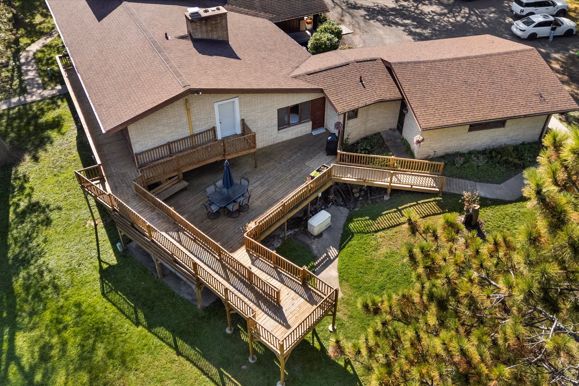 Aerial view of a single-story building with expansive wooden deck and outdoor seating.