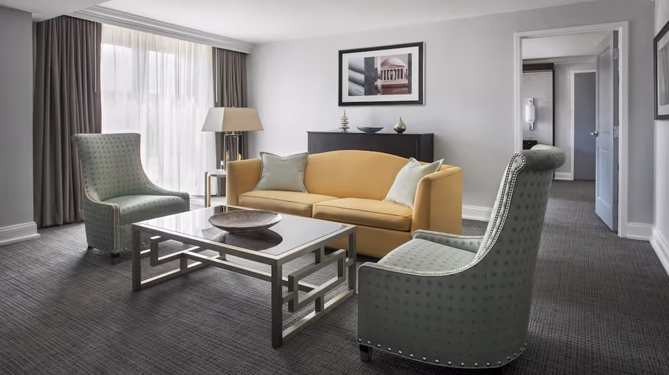 Bright living room lounge with a yellow sofa and two teal chairs.