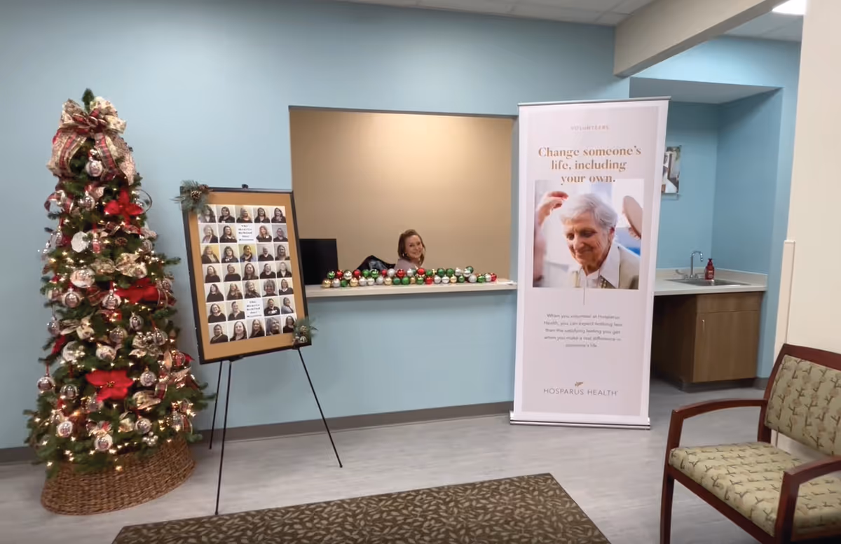 Reception area with a Christmas tree, framed photo board, banner, and counter.