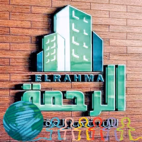 Brick exterior wall with green signage logo reading ELRAHMA and colorful figures.