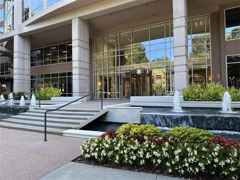 Exterior entrance of Passion to Care Home Care with steps, glass doors, and water features.