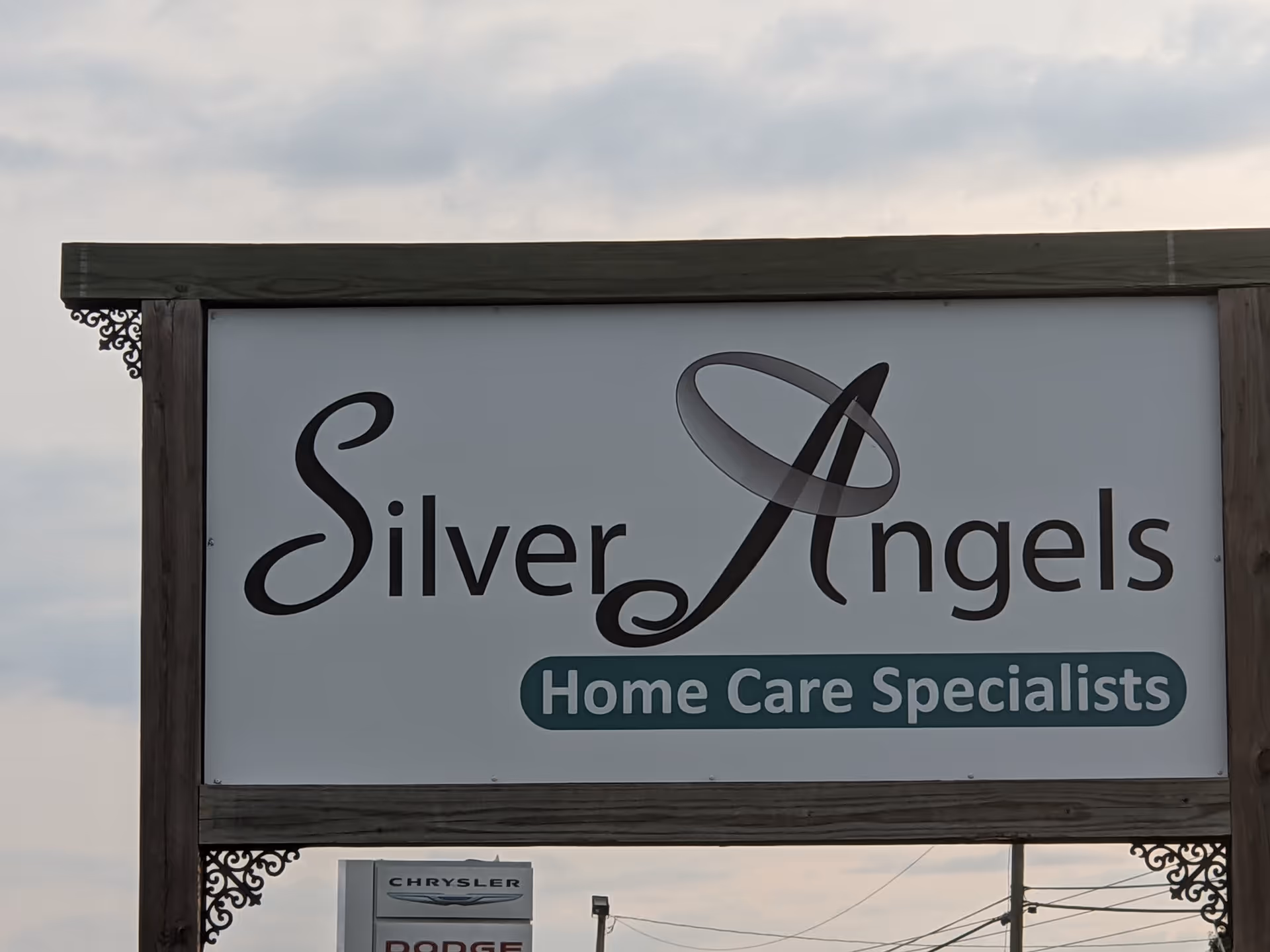 A wooden-framed outdoor sign reading Silver Angels Home Care Specialists.