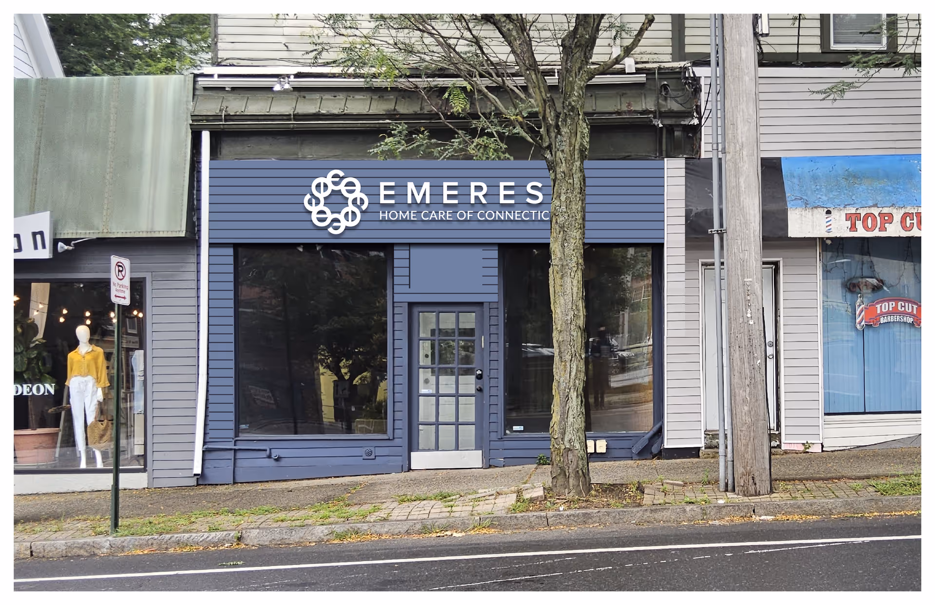 Storefront of Emerest Home Care of Connecticut with blue signage and a tree in front.