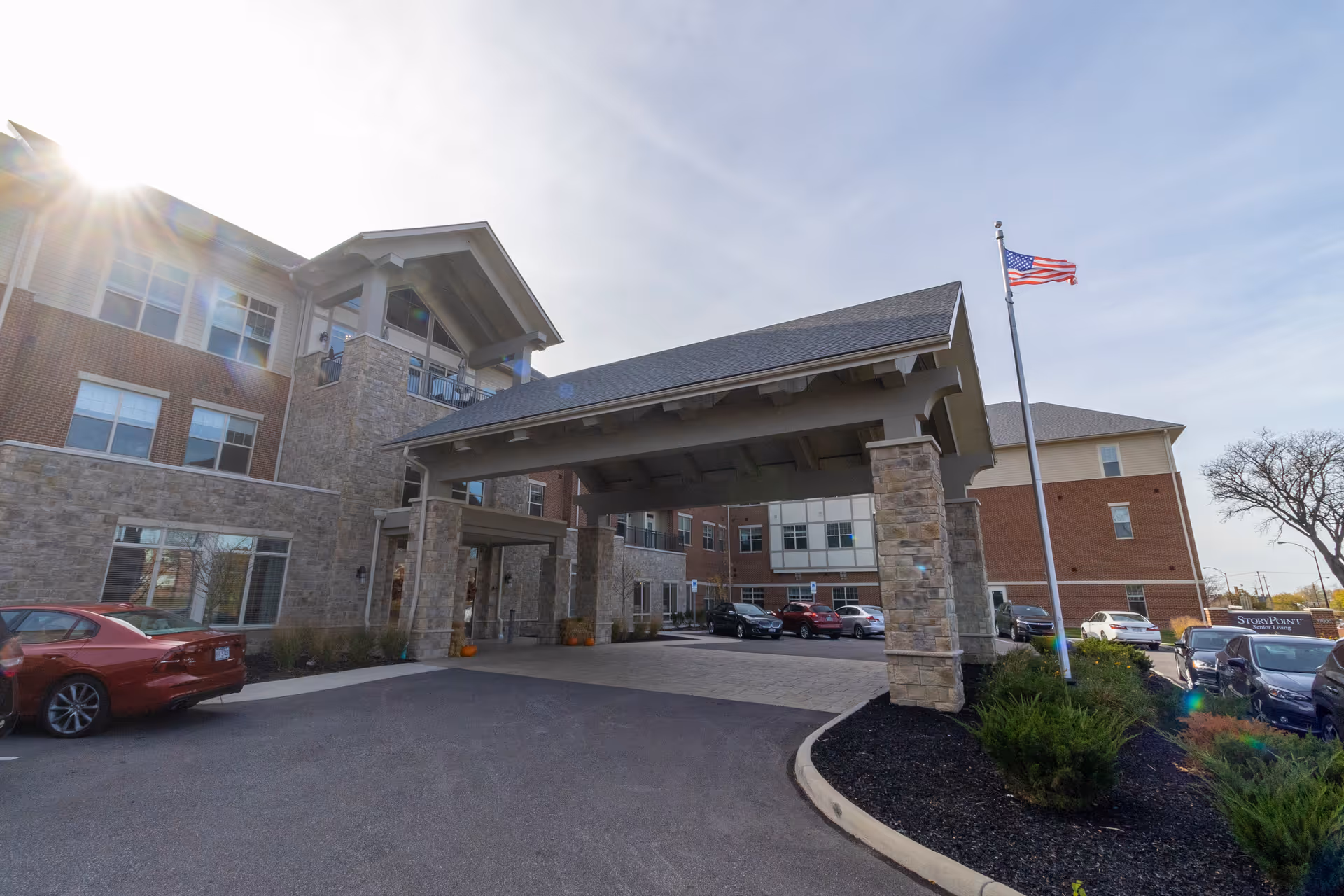 Senior living facility entrance with a stone facade and covered porte-cochere.