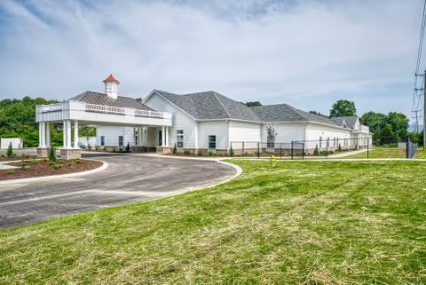 Exterior view of Bailey Manor front entrance with circular driveway and green lawn.