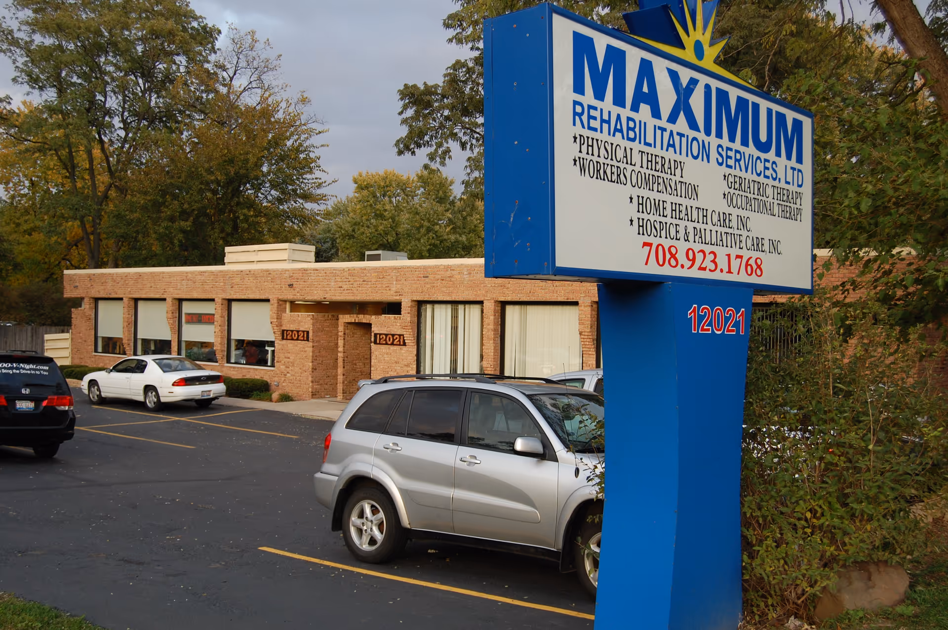 Blue and white sign for Maximum Rehabilitation Services in front of a brick building.