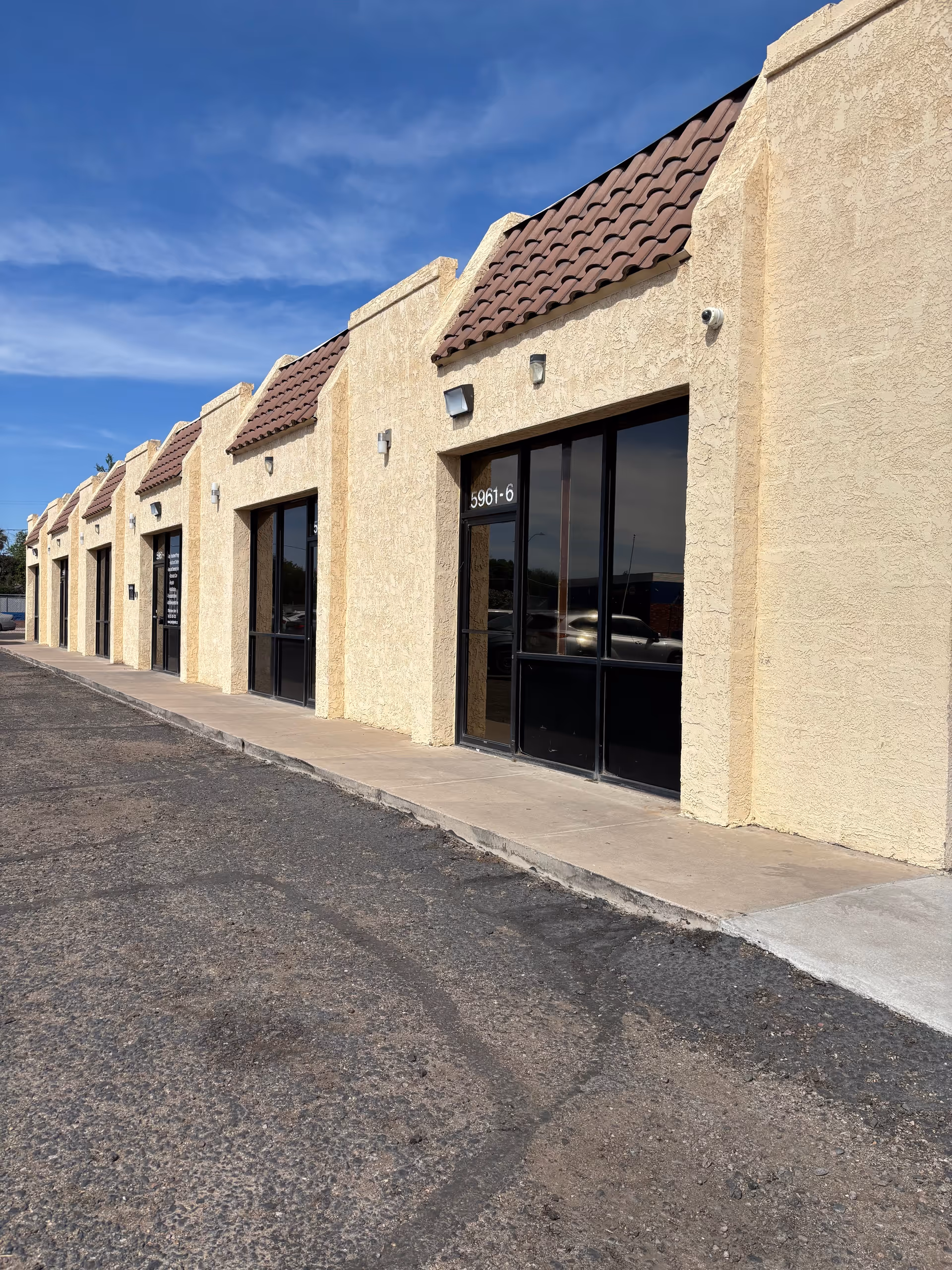 Exterior view of a beige senior living facility with glass storefront doors.
