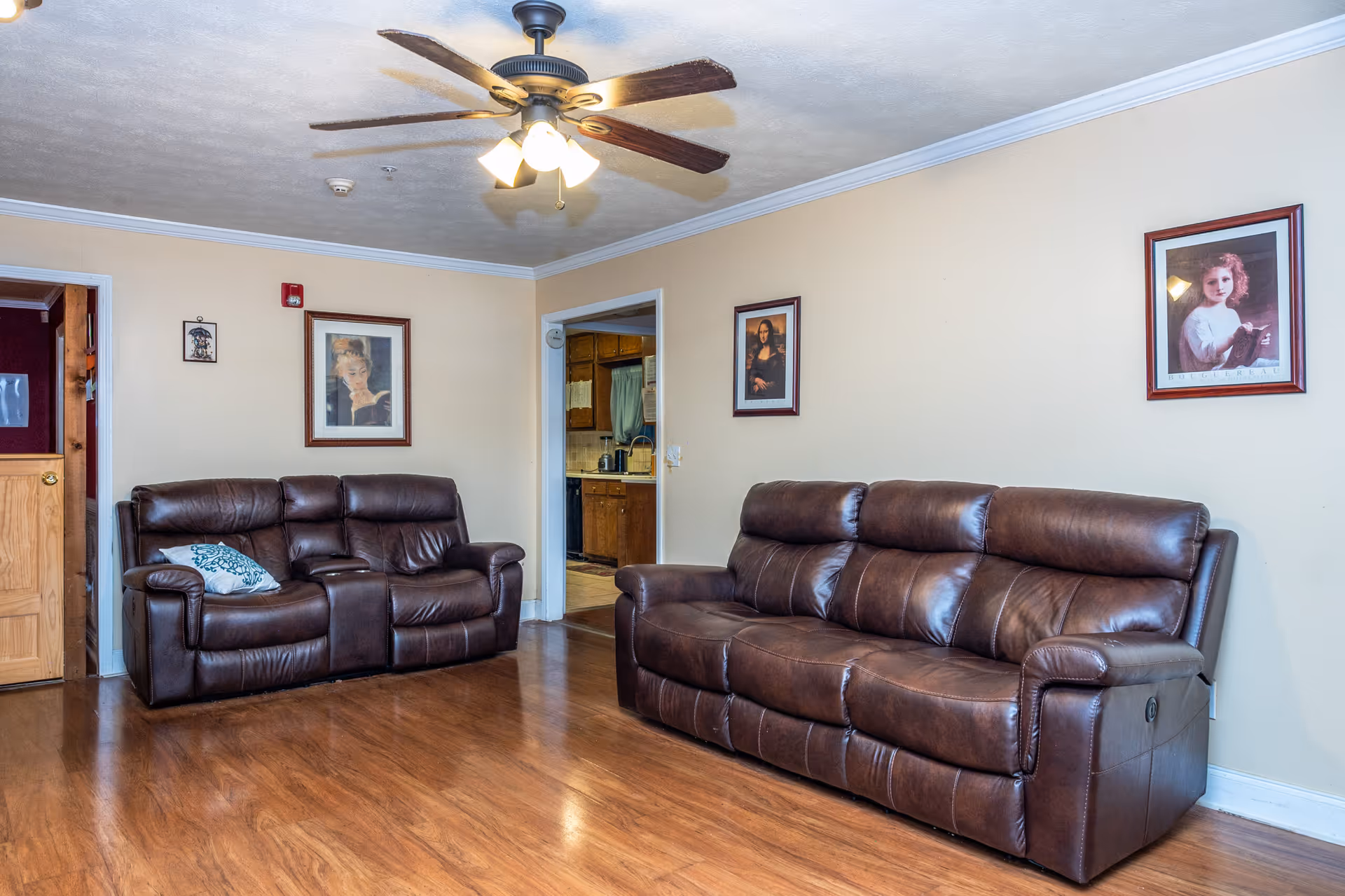 Bright Rose Personal Care Home living room with two brown leather sofas and wall art.