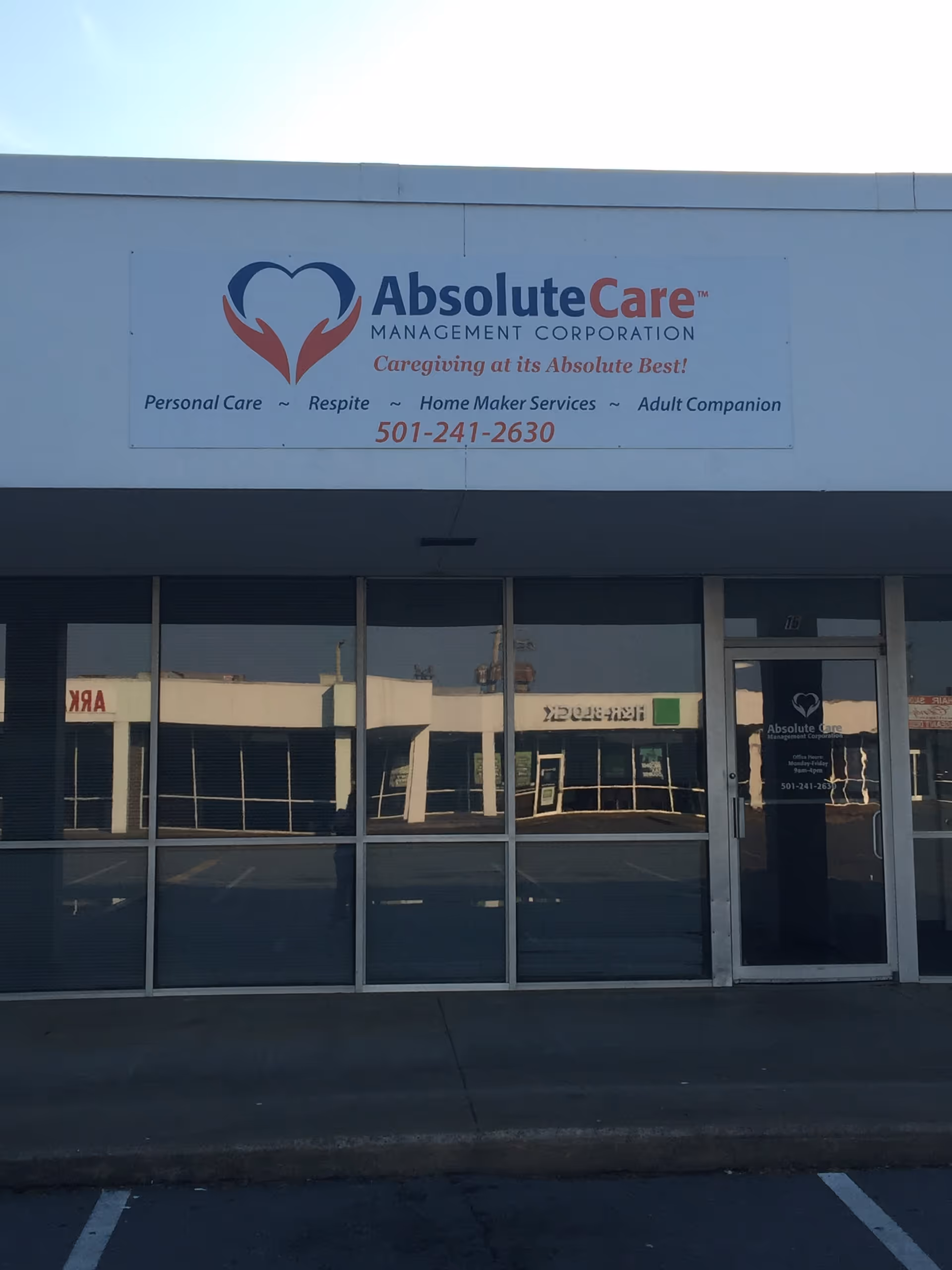 Facade of AbsoluteCare facility with large logo sign above glass storefront.