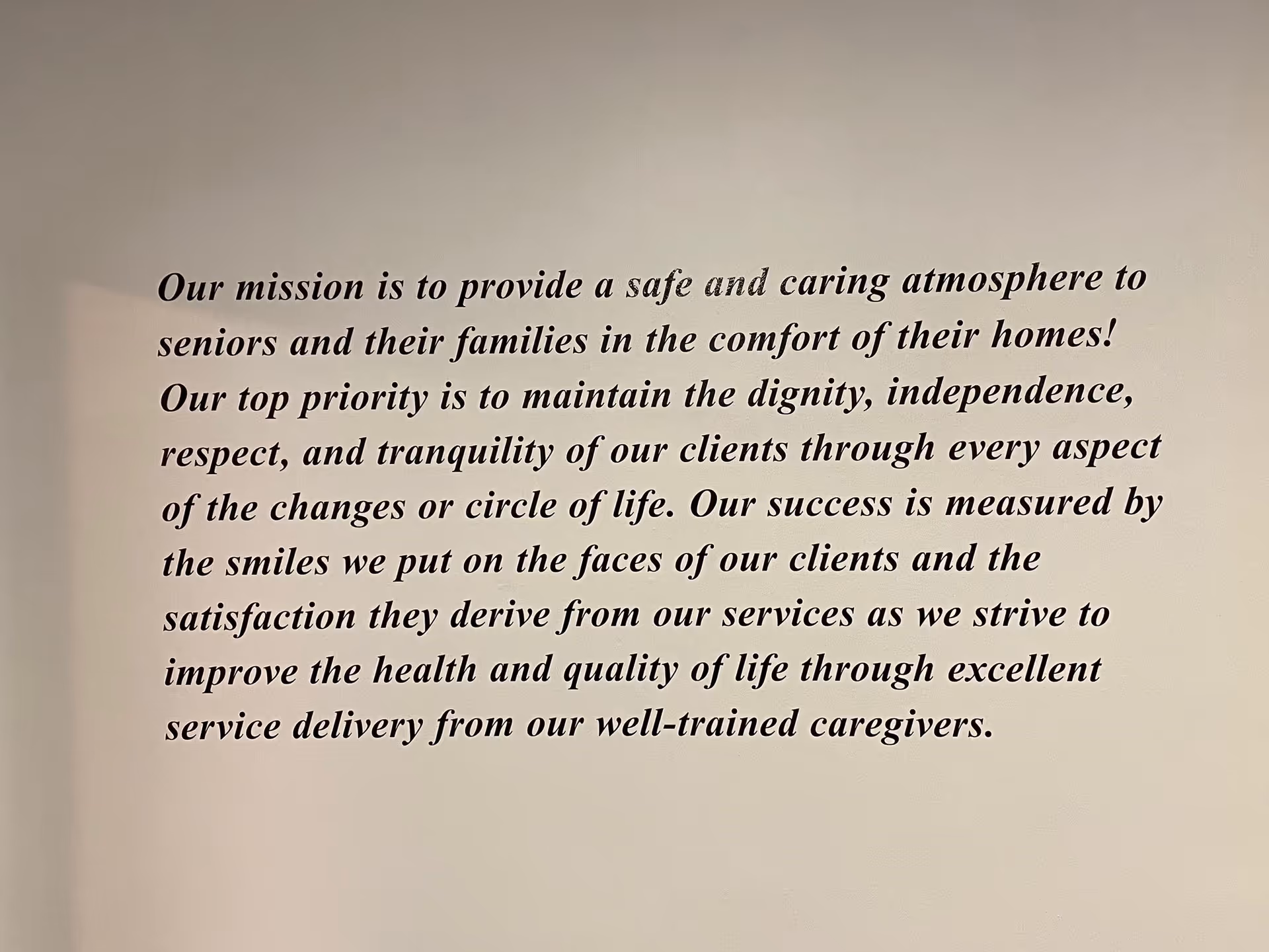 Interior wall features a large scripted mission statement about senior care.